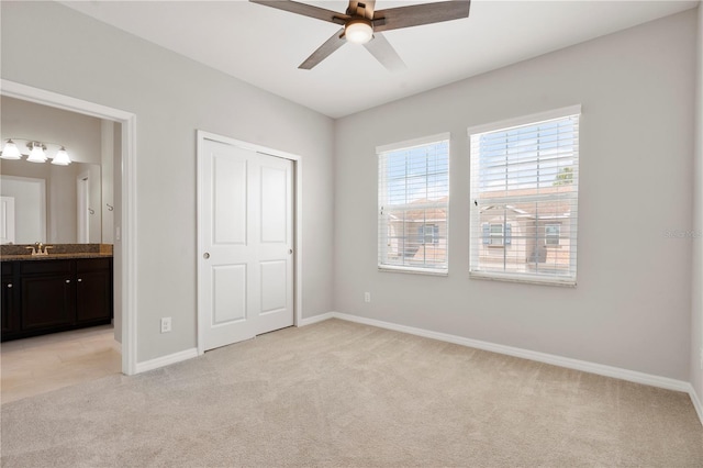 6711 Rocky Park St, Tampa, FL 33625 - unfurnished bedroom featuring light carpet, baseboards, ensuite bathroom, a sink, and ceiling fan