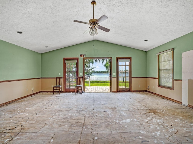 14808 Lake Magdalene Cir, Tampa, FL 33613 - unfurnished living room featuring a textured ceiling, vaulted ceiling, ceiling fan, a water view, and baseboards