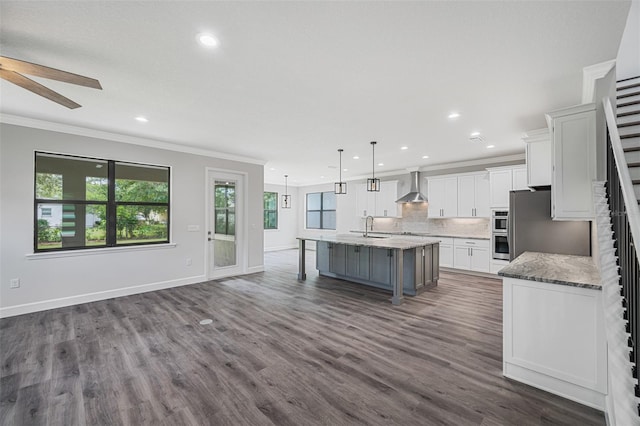 14808 Lake Magdalene Cir, Tampa, FL 33613 - kitchen featuring wall chimney range hood, crown molding, white cabinets, ceiling fan, and open floor plan