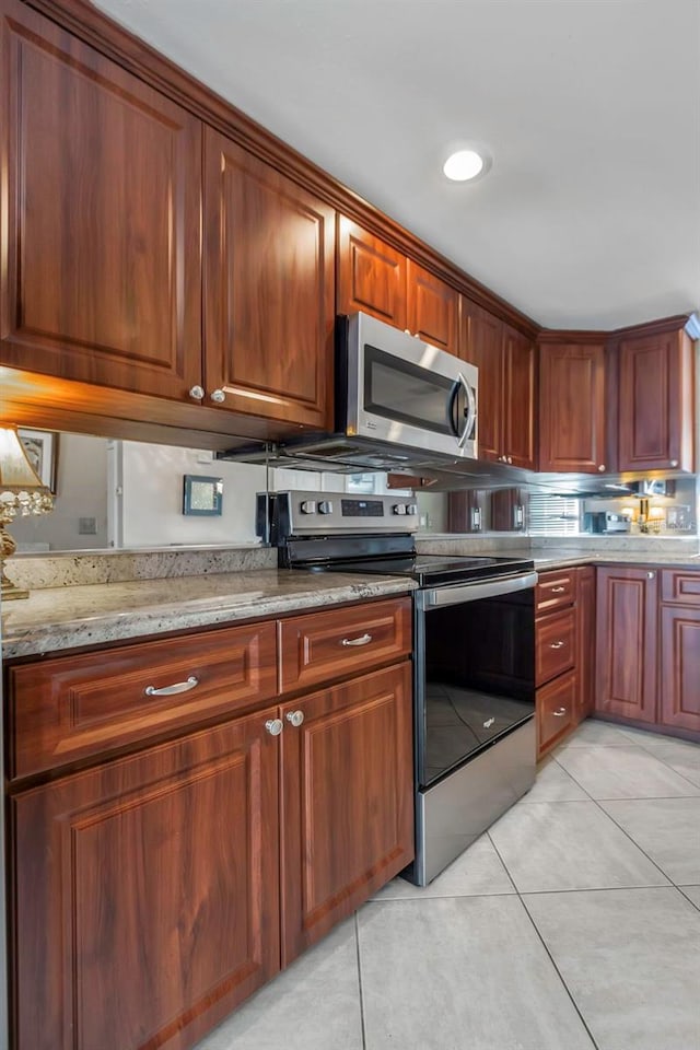 7300 Sun Island Dr S Unit 1505, South Pasadena, FL 33707 - kitchen featuring appliances with stainless steel finishes, light tile patterned floors, and light stone countertops