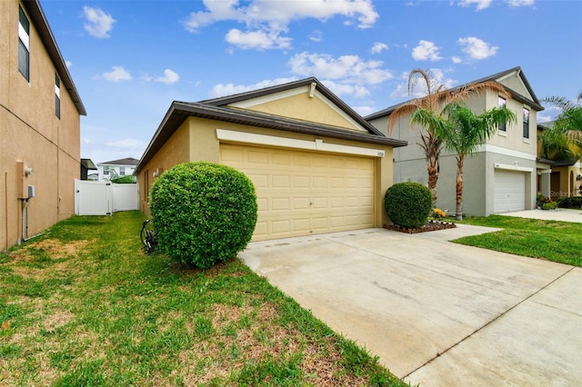 14206 Covert Green Pl, Riverview, FL 33579 - view of home's exterior with stucco siding, driveway, and a gate