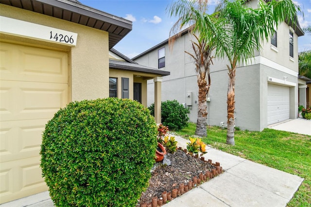 14206 Covert Green Pl, Riverview, FL 33579 - entrance to property featuring stucco siding, a garage, and driveway