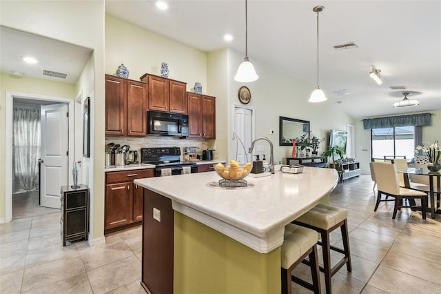 14206 Covert Green Pl, Riverview, FL 33579 - kitchen with black appliances, light countertops, a breakfast bar, hanging light fixtures, and a kitchen island with sink