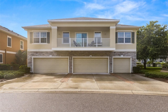 7001 Interbay Blvd Unit 242, Tampa, FL 33616 - view of property featuring concrete driveway, an attached garage, stucco siding, and stone siding