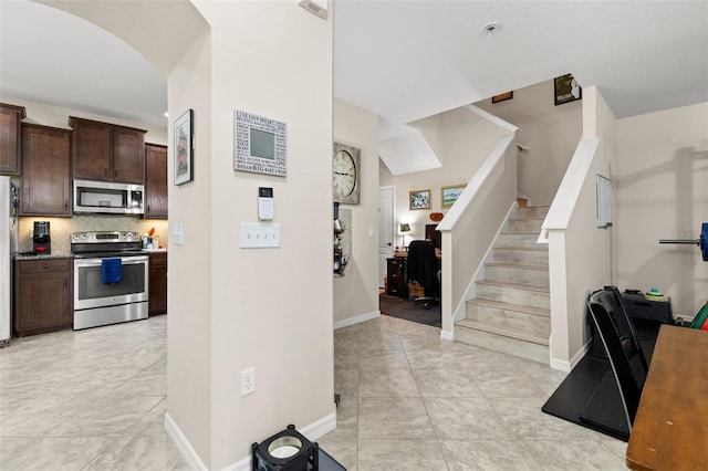 7001 Interbay Blvd Unit 242, Tampa, FL 33616 - foyer entrance with stairs, arched walkways, and baseboards