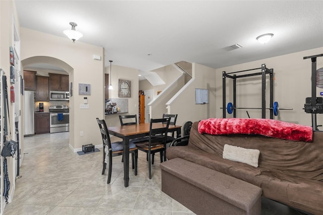 7001 Interbay Blvd Unit 242, Tampa, FL 33616 - dining room with arched walkways, stairway, and baseboards