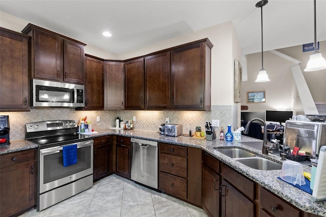 7001 Interbay Blvd Unit 242, Tampa, FL 33616 - kitchen featuring stainless steel appliances, a sink, dark brown cabinetry, and light stone countertops