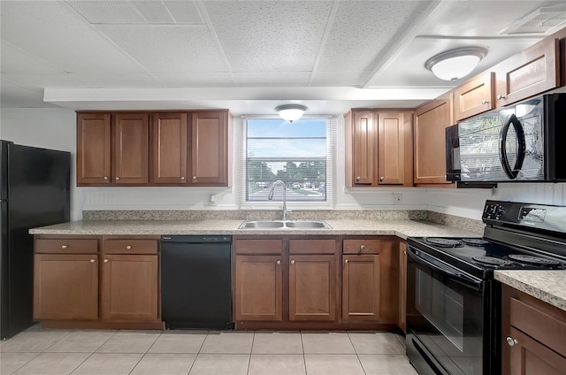 7524 Tidewater Trl, Tampa, FL 33619 - kitchen with black appliances, a sink, light countertops, brown cabinets, and a drop ceiling