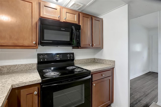 7524 Tidewater Trl, Tampa, FL 33619 - kitchen featuring black appliances, light countertops, wood finished floors, and baseboards