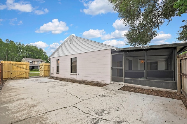 1717 Osprey Ln, Lutz, FL 33549 - rear view of house featuring a sunroom, a gate, and a patio area