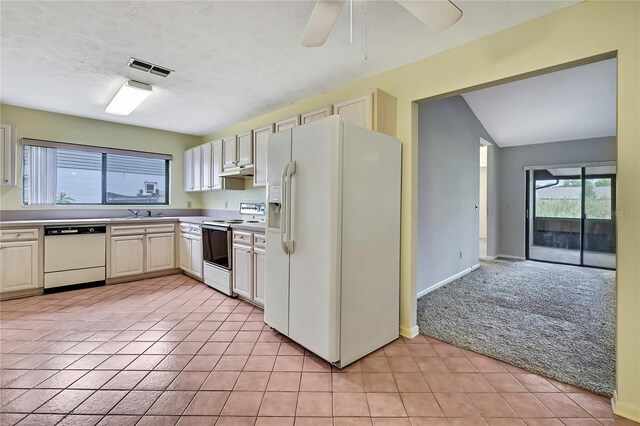 1717 Osprey Ln, Lutz, FL 33549 - kitchen featuring white appliances, light tile patterned floors, light carpet, a ceiling fan, and light countertops