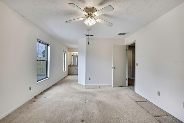 1717 Osprey Ln, Lutz, FL 33549 - unfurnished bedroom featuring light carpet, baseboards, ensuite bathroom, and ceiling fan