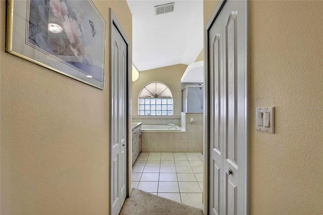 6121 Piedmont Dr, Spring Hill, FL 34606 - bathroom with a garden tub, tile patterned flooring, a textured wall, a closet, and lofted ceiling