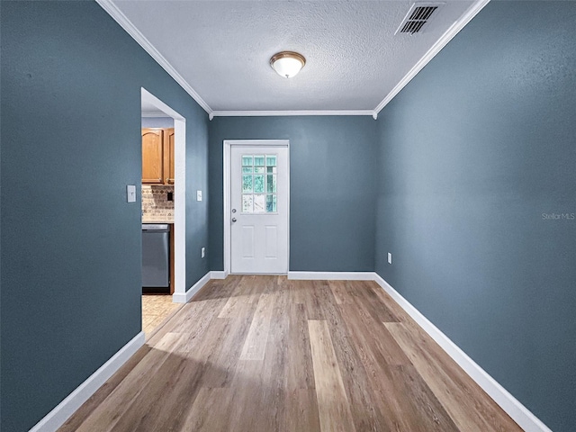 1238 Honeytree Ln E, Lakeland, FL 33801 - unfurnished dining area featuring light wood-style flooring, crown molding, baseboards, and a textured ceiling