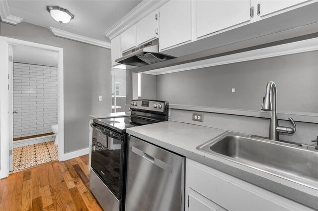 1301 S Howard Ave Unit A22, Tampa, FL 33606 - kitchen with appliances with stainless steel finishes, a sink, under cabinet range hood, light countertops, and white cabinetry
