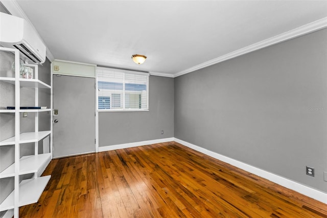 1301 S Howard Ave Unit A22, Tampa, FL 33606 - unfurnished room featuring an AC wall unit, baseboards, wood-type flooring, and ornamental molding