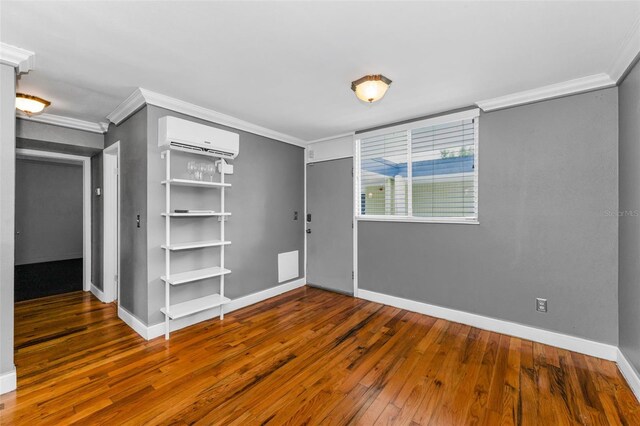 1301 S Howard Ave Unit A22, Tampa, FL 33606 - entrance foyer with a wall unit AC, crown molding, hardwood / wood-style floors, and baseboards