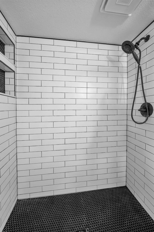 1301 S Howard Ave Unit A22, Tampa, FL 33606 - full bathroom featuring a textured ceiling and a tile shower