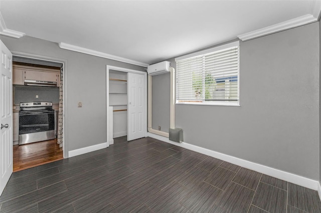 1301 S Howard Ave Unit A22, Tampa, FL 33606 - unfurnished bedroom with crown molding, a wall unit AC, baseboards, and dark wood finished floors