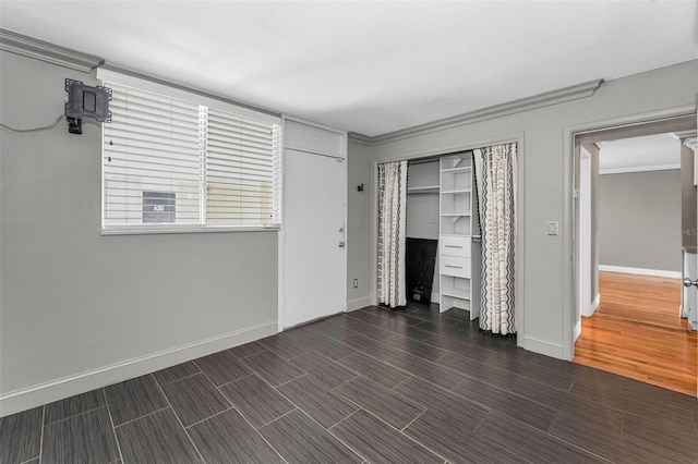 1301 S Howard Ave Unit A22, Tampa, FL 33606 - unfurnished bedroom featuring baseboards, crown molding, a closet, and dark wood finished floors
