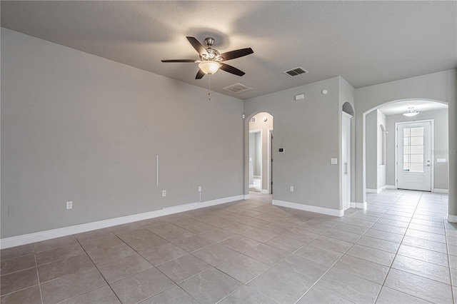 19974 Bluebird Meadow Dr, Lutz, FL 33558 - empty room featuring arched walkways, a ceiling fan, and light tile patterned floors