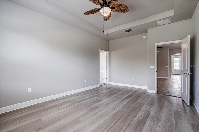 19974 Bluebird Meadow Dr, Lutz, FL 33558 - empty room featuring a raised ceiling, ceiling fan, and light wood finished floors