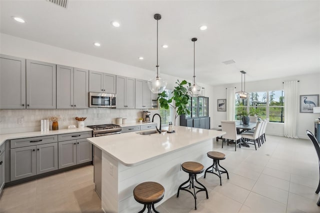 32490 Tree Of Life Ave, Wesley Chapel, FL 33543 - kitchen with stainless steel appliances, gray cabinetry, light tile patterned flooring, light countertops, and recessed lighting