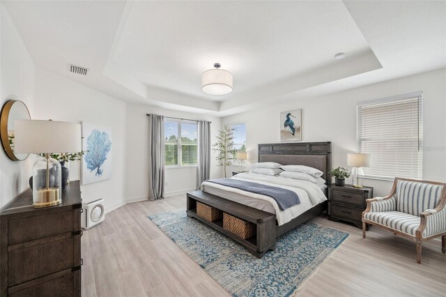 32490 Tree Of Life Ave, Wesley Chapel, FL 33543 - bedroom with a raised ceiling, light wood-style flooring, and baseboards
