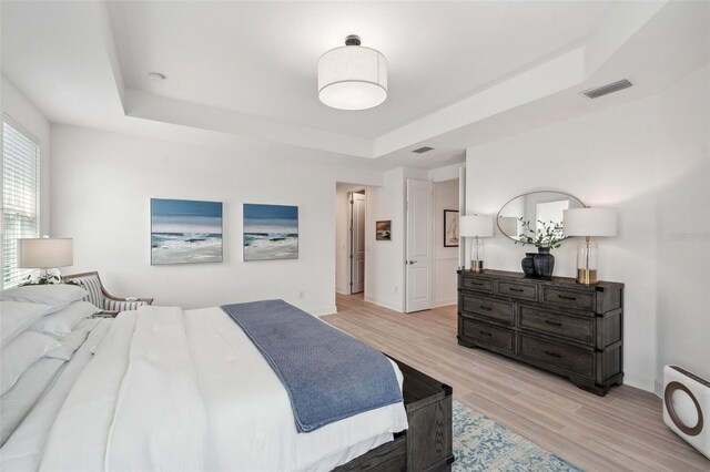 32490 Tree Of Life Ave, Wesley Chapel, FL 33543 - bedroom featuring a raised ceiling, light wood finished floors, and baseboards