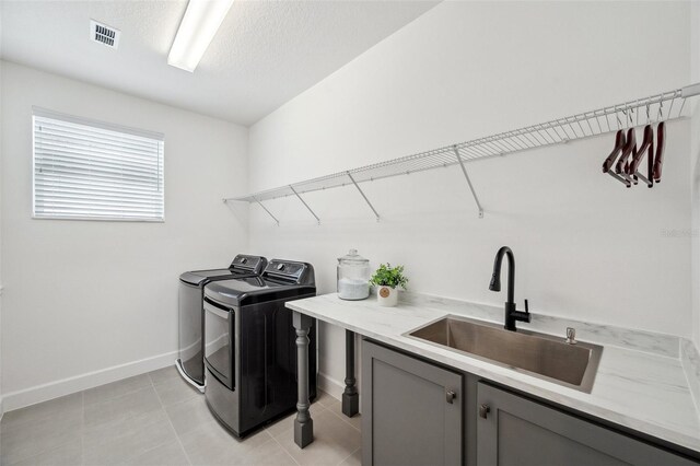 32490 Tree Of Life Ave, Wesley Chapel, FL 33543 - laundry room featuring cabinet space, washer and dryer, baseboards, a textured ceiling, and light tile patterned floors