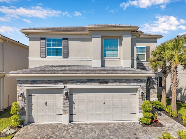 32490 Tree Of Life Ave, Wesley Chapel, FL 33543 - view of front facade with a garage, stone siding, and decorative driveway