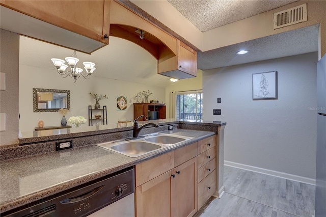 2500 Winding Creek Blvd Unit G307, Clearwater, FL 33761 - kitchen with stainless steel dishwasher, a sink, dark countertops, light wood-type flooring, and a textured ceiling