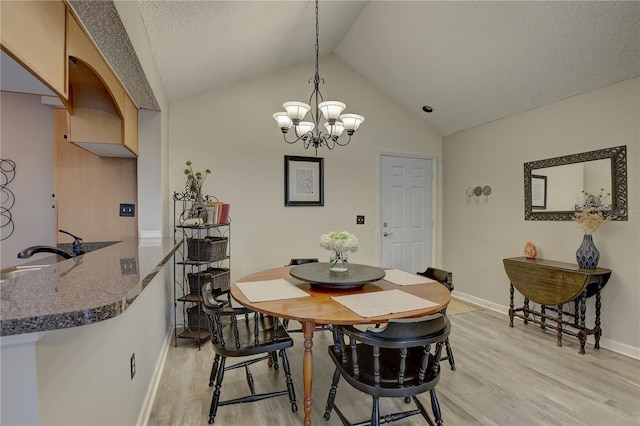 2500 Winding Creek Blvd Unit G307, Clearwater, FL 33761 - dining room featuring light wood-type flooring, a chandelier, baseboards, lofted ceiling, and a textured ceiling