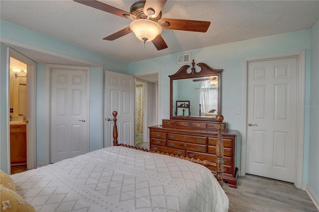 2500 Winding Creek Blvd Unit G307, Clearwater, FL 33761 - bedroom with wood finished floors, a textured ceiling, ceiling fan, and ensuite bathroom