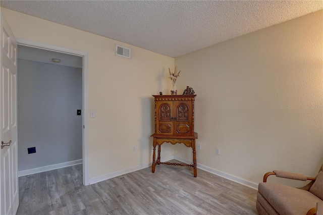 2500 Winding Creek Blvd Unit G307, Clearwater, FL 33761 - sitting room featuring light wood-style flooring, a textured ceiling, and baseboards