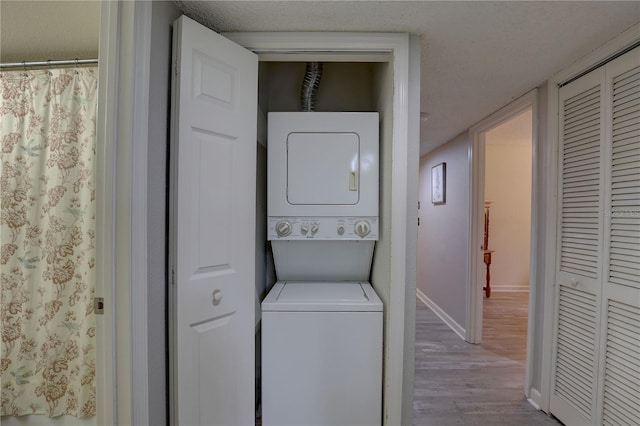 2500 Winding Creek Blvd Unit G307, Clearwater, FL 33761 - laundry area featuring stacked washer / drying machine, wood finished floors, and baseboards