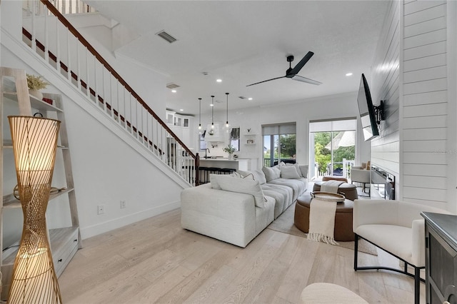 6512 Simone Shores Cir, Apollo Beach, FL 33572 - living area with light wood finished floors, ceiling fan, stairs, a fireplace, and recessed lighting