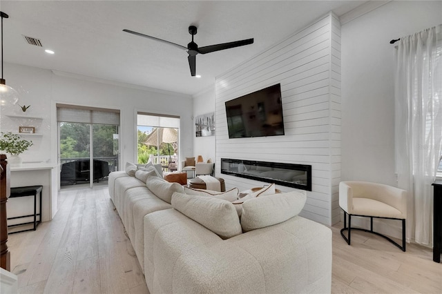 6512 Simone Shores Cir, Apollo Beach, FL 33572 - living room featuring light wood-style flooring, a ceiling fan, a fireplace, ornamental molding, and recessed lighting