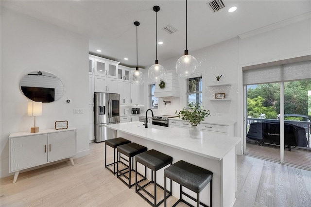 6512 Simone Shores Cir, Apollo Beach, FL 33572 - kitchen with appliances with stainless steel finishes, light wood-style flooring, light countertops, a kitchen bar, and recessed lighting