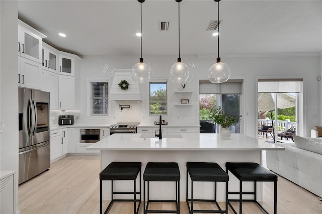 6512 Simone Shores Cir, Apollo Beach, FL 33572 - kitchen with appliances with stainless steel finishes, a sink, backsplash, light countertops, and light wood finished floors
