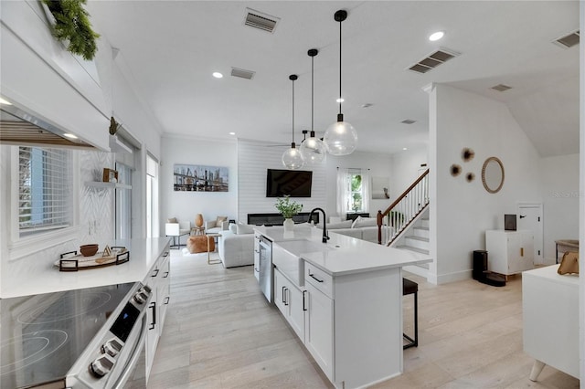 6512 Simone Shores Cir, Apollo Beach, FL 33572 - kitchen with stainless steel appliances, open floor plan, a sink, white cabinets, and a breakfast bar
