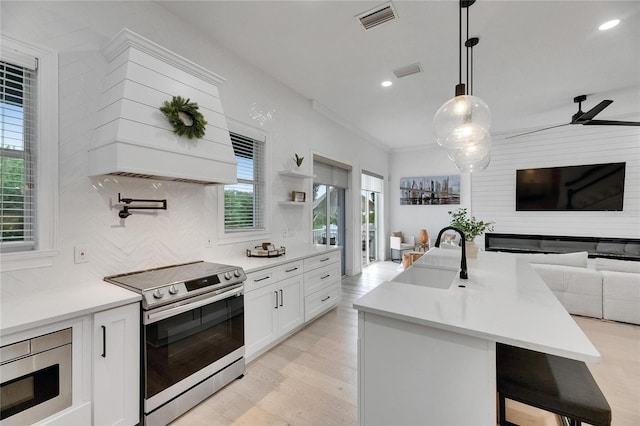 6512 Simone Shores Cir, Apollo Beach, FL 33572 - kitchen with appliances with stainless steel finishes, open floor plan, a sink, white cabinetry, and backsplash