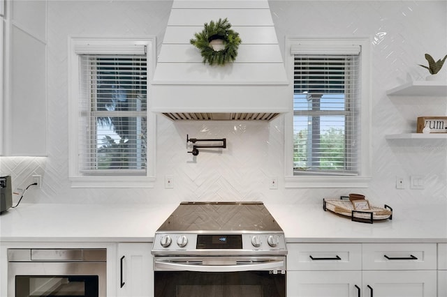 6512 Simone Shores Cir, Apollo Beach, FL 33572 - kitchen with appliances with stainless steel finishes, premium range hood, and white cabinets