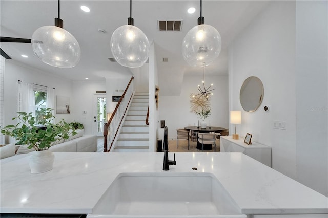 6512 Simone Shores Cir, Apollo Beach, FL 33572 - kitchen featuring open floor plan, a sink, light stone countertops, pendant lighting, and recessed lighting
