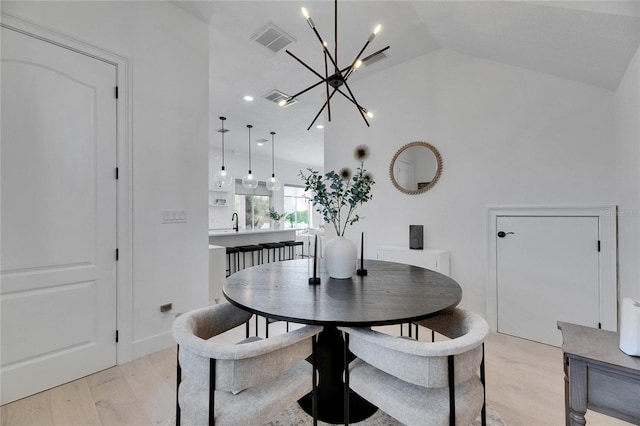 6512 Simone Shores Cir, Apollo Beach, FL 33572 - dining area with light wood-type flooring, a chandelier, and vaulted ceiling