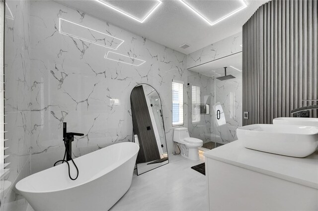 6512 Simone Shores Cir, Apollo Beach, FL 33572 - bathroom with a marble finish shower, marble tiled floors, stone wall, and a soaking tub