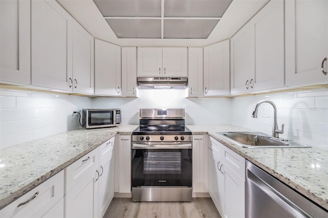 2699 Seville Blvd Unit 207, Clearwater, FL 33764 - kitchen featuring appliances with stainless steel finishes, under cabinet range hood, a sink, and white cabinets