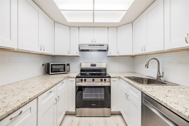 2699 Seville Blvd Unit 207, Clearwater, FL 33764 - kitchen with stainless steel appliances, range hood, a sink, and decorative backsplash