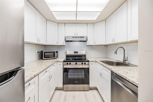 2699 Seville Blvd Unit 207, Clearwater, FL 33764 - kitchen featuring stainless steel appliances, a sink, exhaust hood, and white cabinets