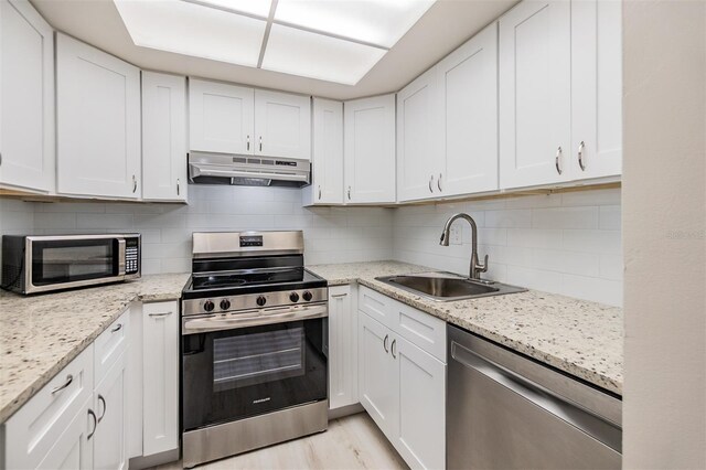 2699 Seville Blvd Unit 207, Clearwater, FL 33764 - kitchen with appliances with stainless steel finishes, under cabinet range hood, a sink, and white cabinetry